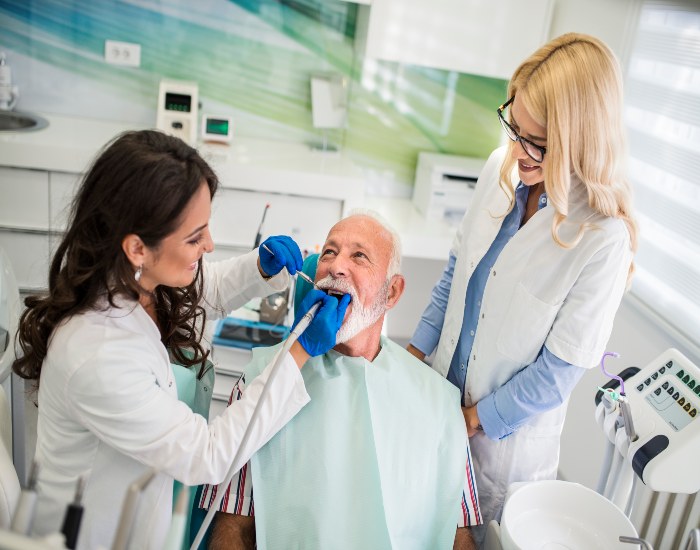 An elderly man is undergoing denture treatment at Reiser Dental in Denver, CO